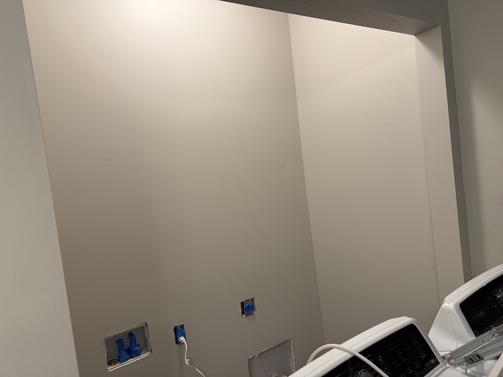 Freshly painted laundry room wall after repair work