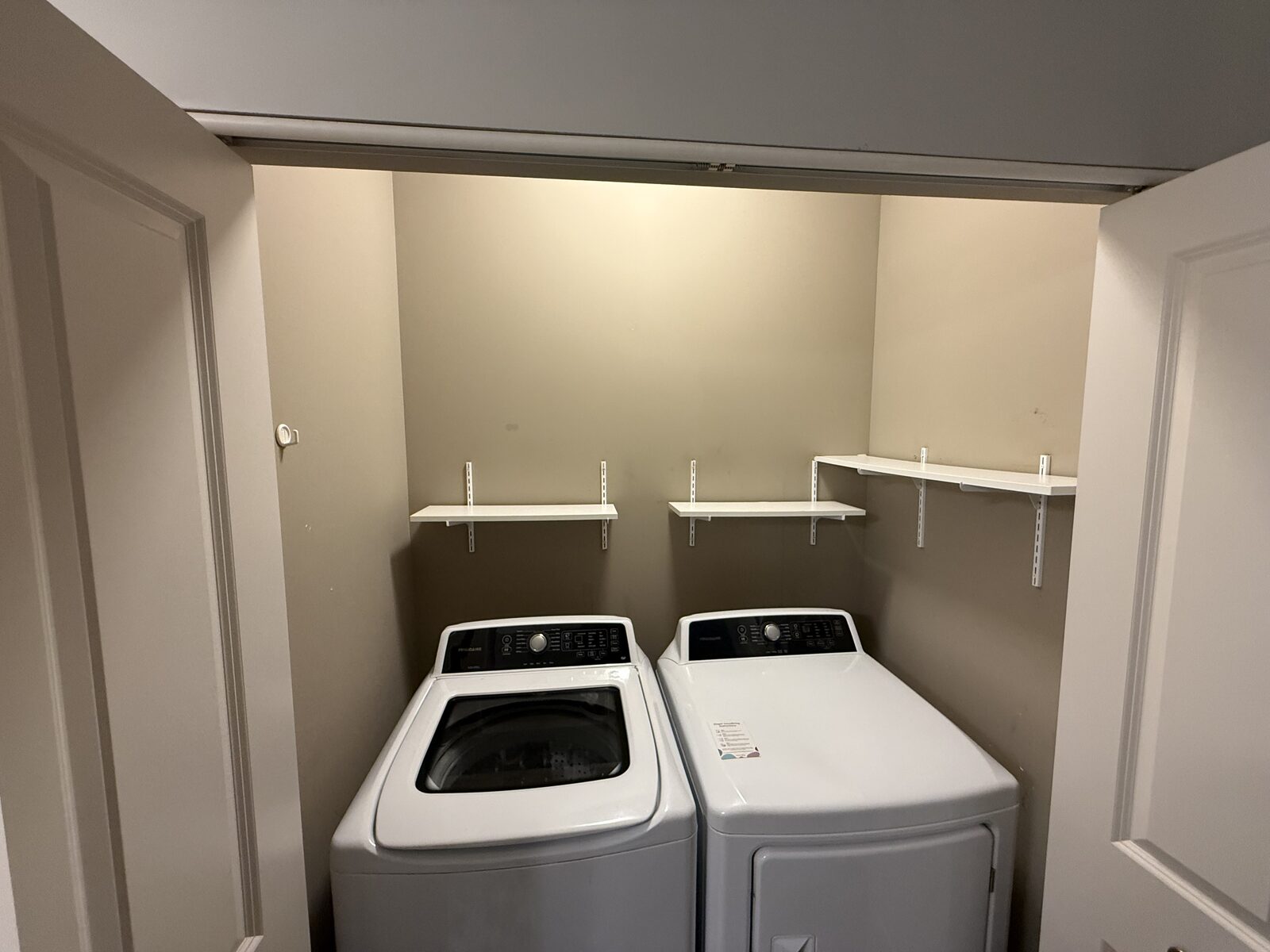 Laundry room with old short mismatched shelves before replacement