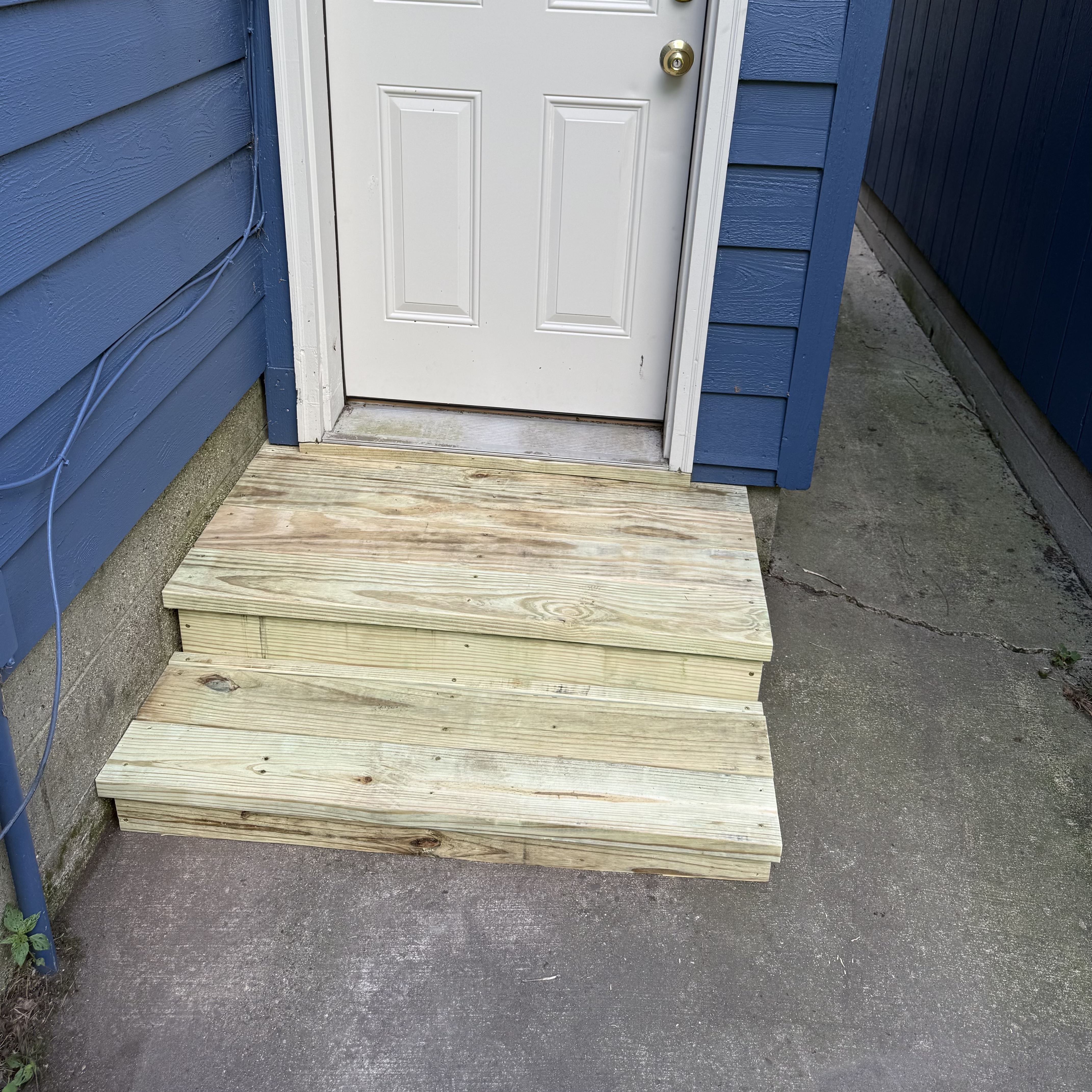 New pressure-treated wooden entry steps after replacement
