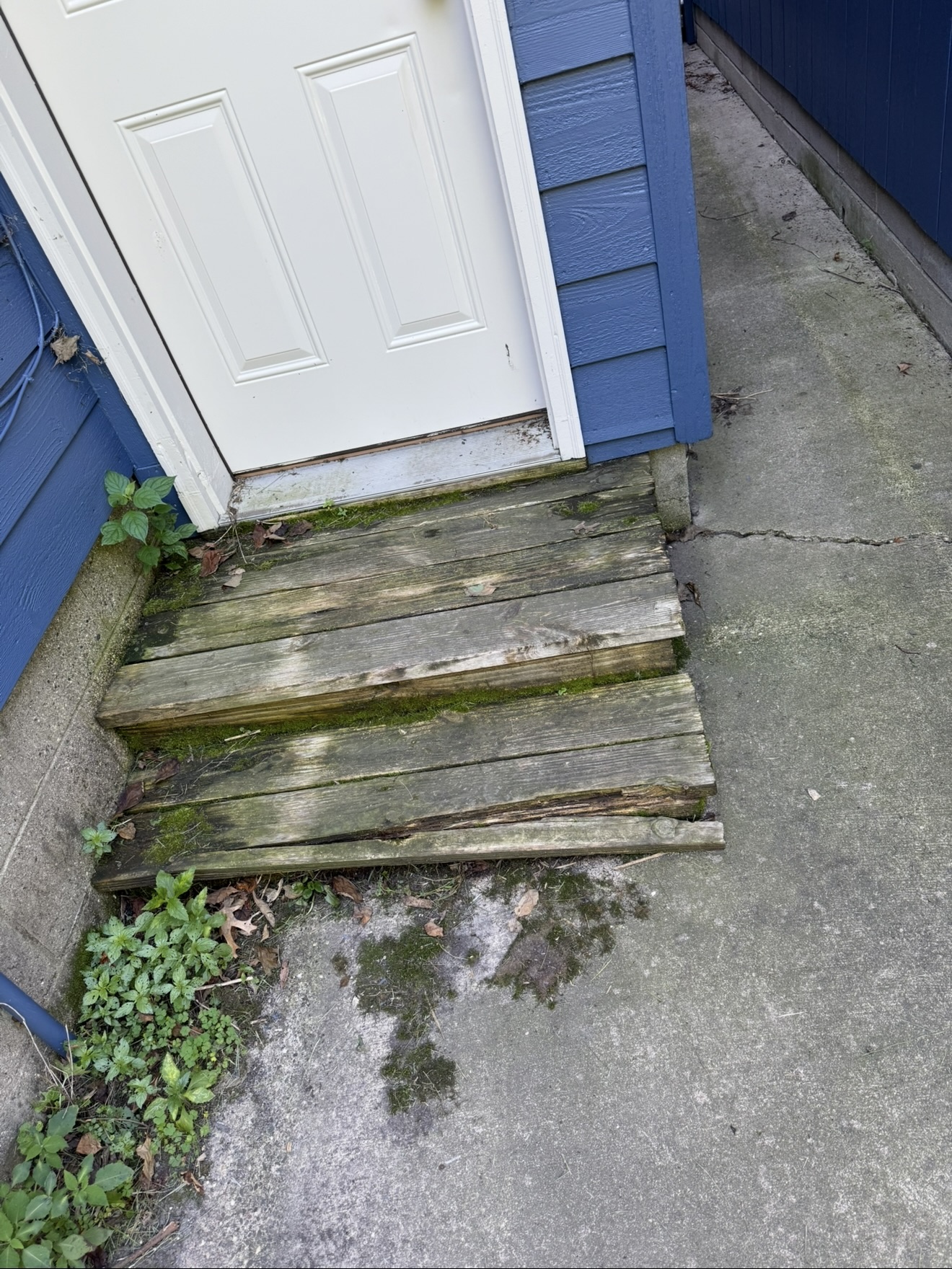 Old weathered wooden entry steps before replacement
